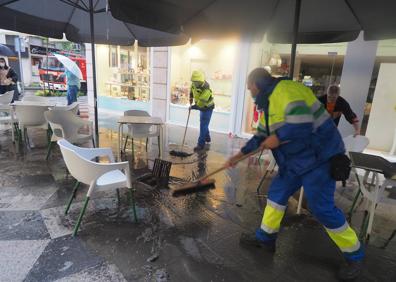 Imagen secundaria 1 - Bomberos y personal municipal intentan quitar el agua en la calle Ruamayor.