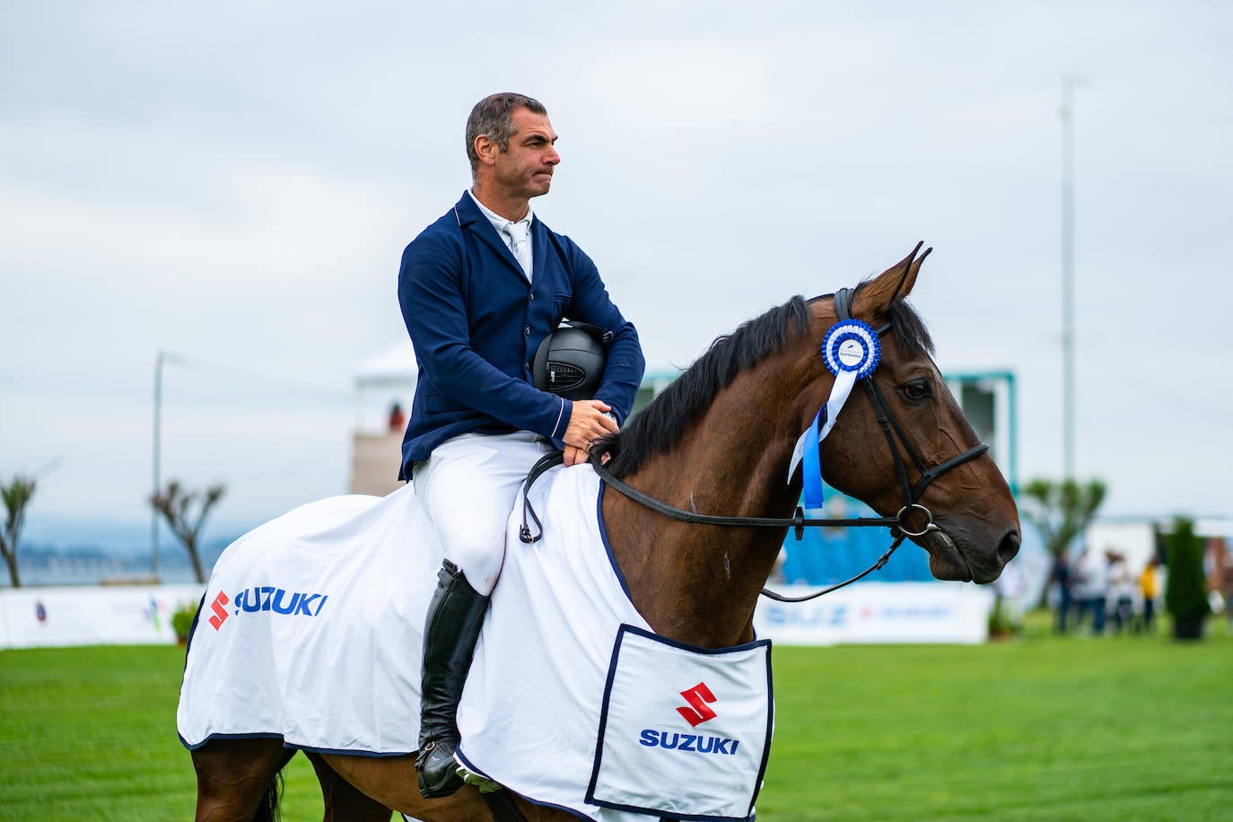 El francés Olivier Camy Sarthy y su caballo 'Carlo Mouche' lucen su escarapela de ganadores.