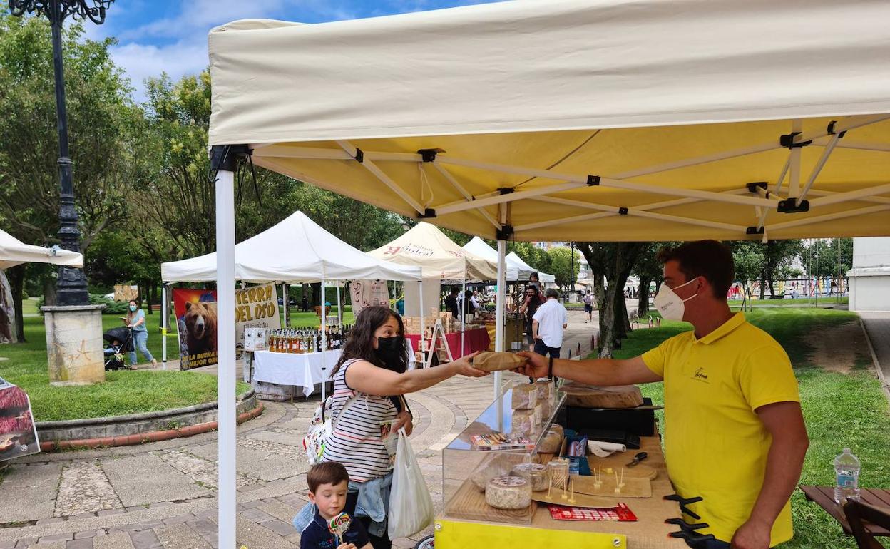Una clienta adquiere unos productos de la quesería El Pendo, este sábado, en el mercado afincado en Cros.