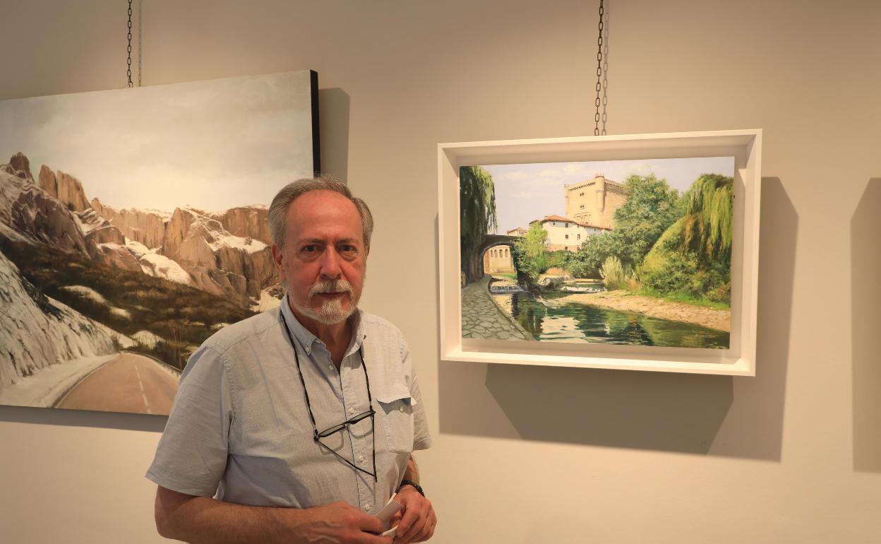 Carlos P. Inclán y el cuadro del paseo junto al río Deva, en la villa de Potes, que muestra en la exposición 