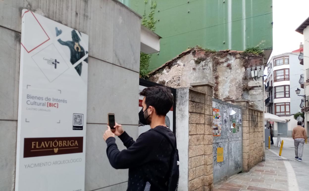 Un ciudadano escanea un código QR en el centro de interpretación de Flavióbriga.