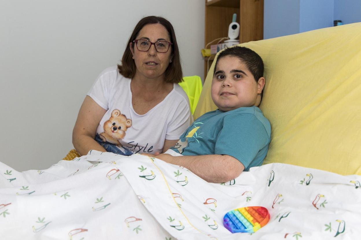 Nieves del Río posa con su hijo, Ismael, en su dormitorio. 