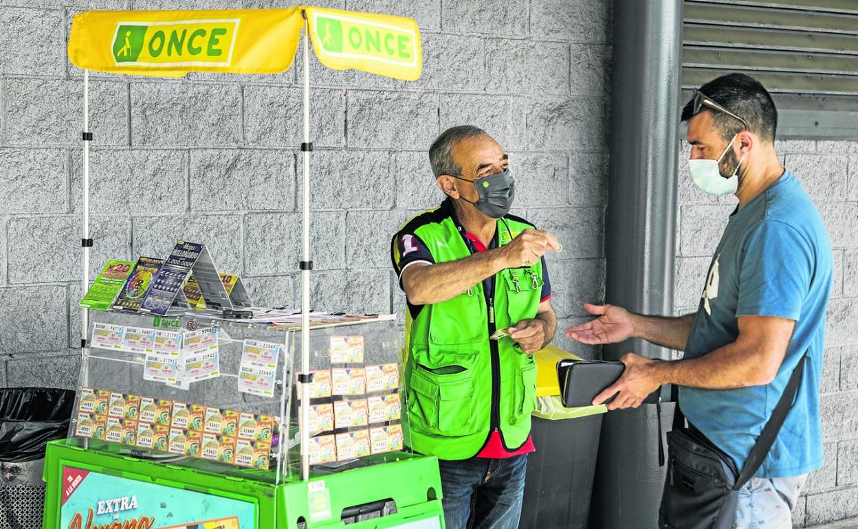 Joaquín Carlos Cobo vendiendo un cupón a un cliente. 