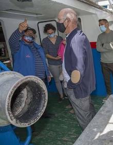 Imagen secundaria 2 - Imagen del mes de mayo de Fernando Solano, mostrando su barco, el Maremi, a un grupo de visitantes durante la Feria de Artes Fijas de Santoña.