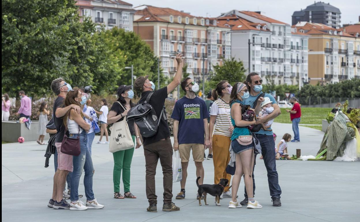 Un grupo de turistas atiende a las explicaciones por la zona del Centro Botín, en Santander. 