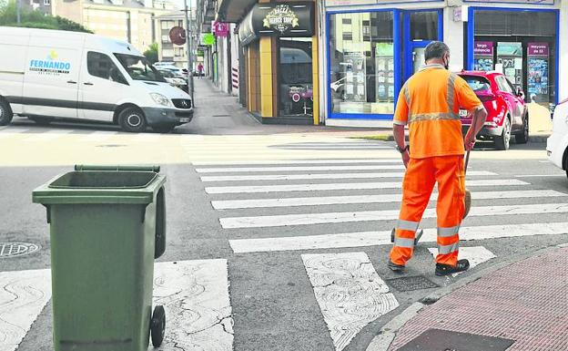 Un operario barre en una calle de Maliaño.