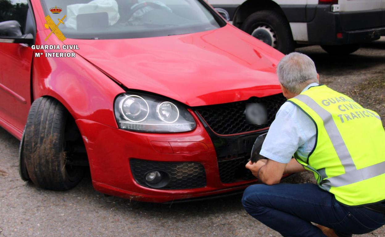 Un agente inspecciona el vehículo siniestrado.