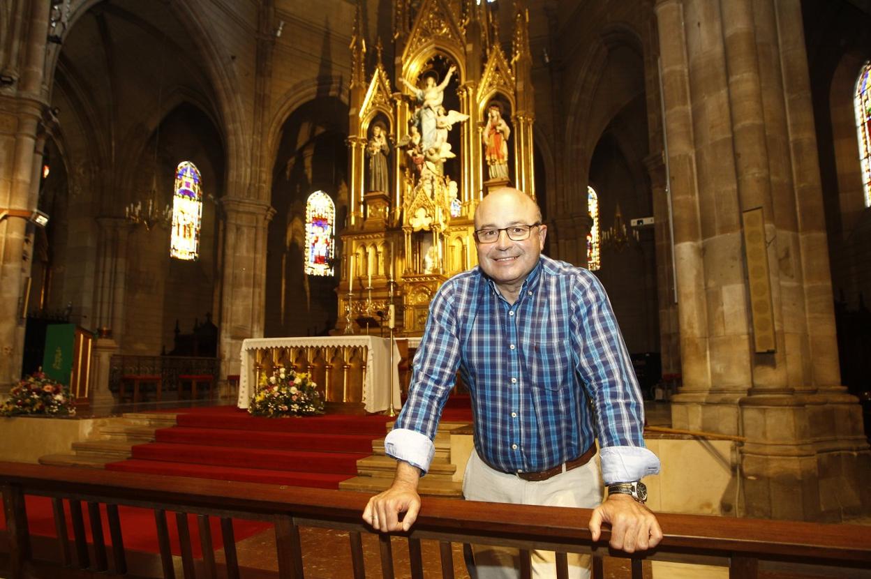 El párroco sonríe en el interior de la iglesia, con el retablo al fondo. luis palomeque