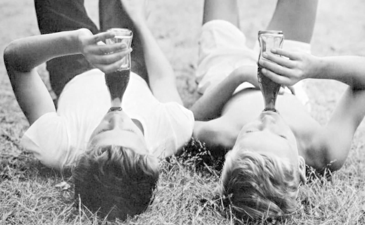 Dos pequeños, entregados a la popular bebida de Cola.