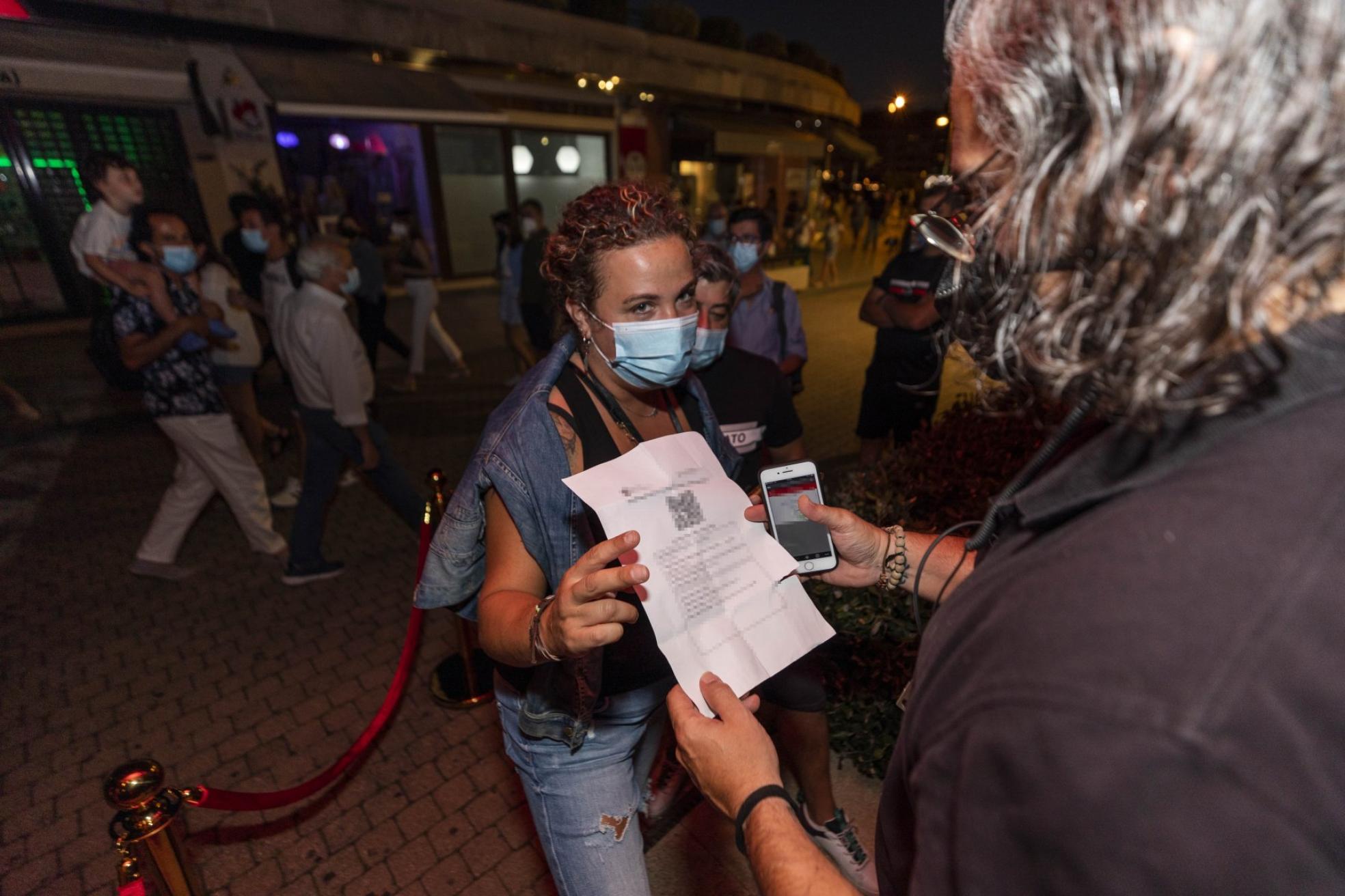 Una mujer muestra su certificado covid en Sanxenxo. 