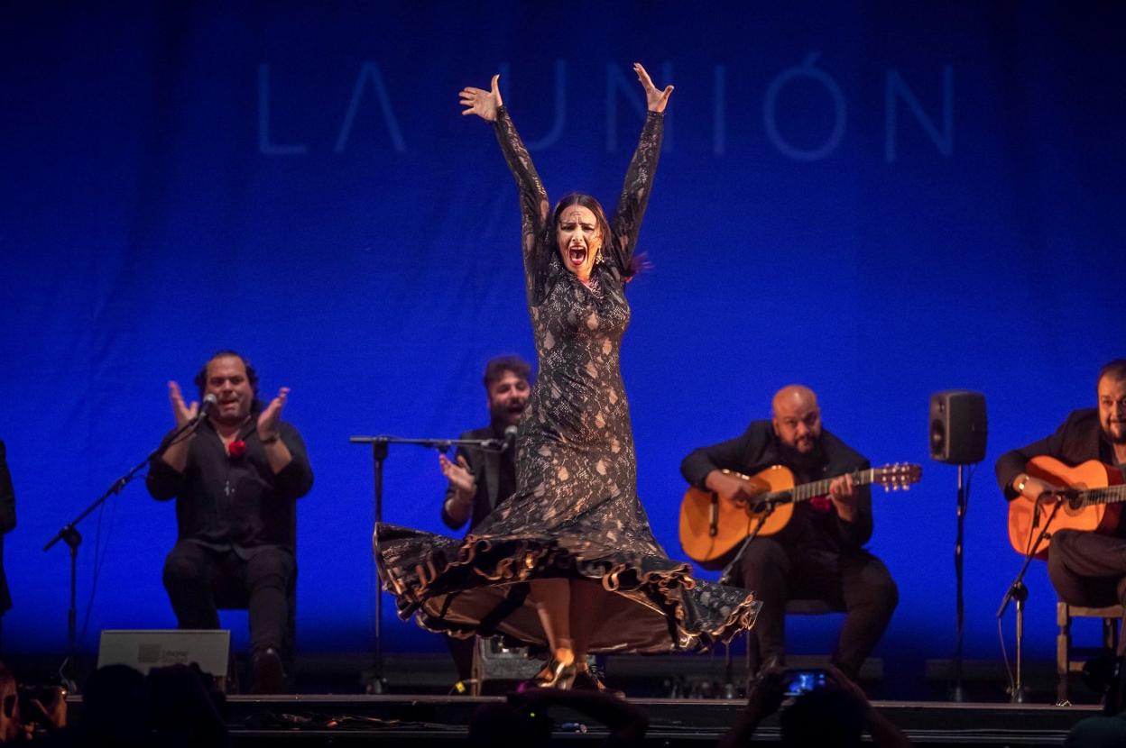 En la imagen superior, la bailaora cántabra en un momento de su actuación y, a la izquierda, con el galardón. 