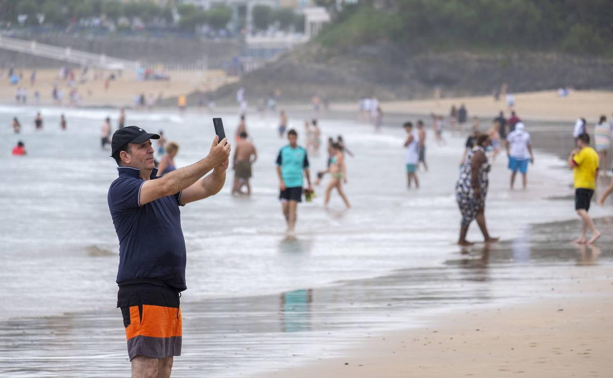 Un turista se hace un selfie en la Primera de El Sardinero. 