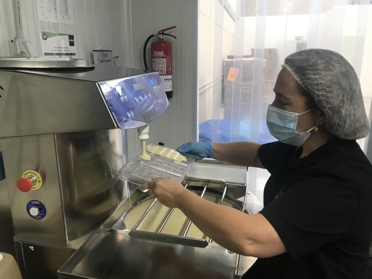 Marián maneja la máquina atemperadora que prepara la mezcla y dosifica el chocolate en tabletas. 