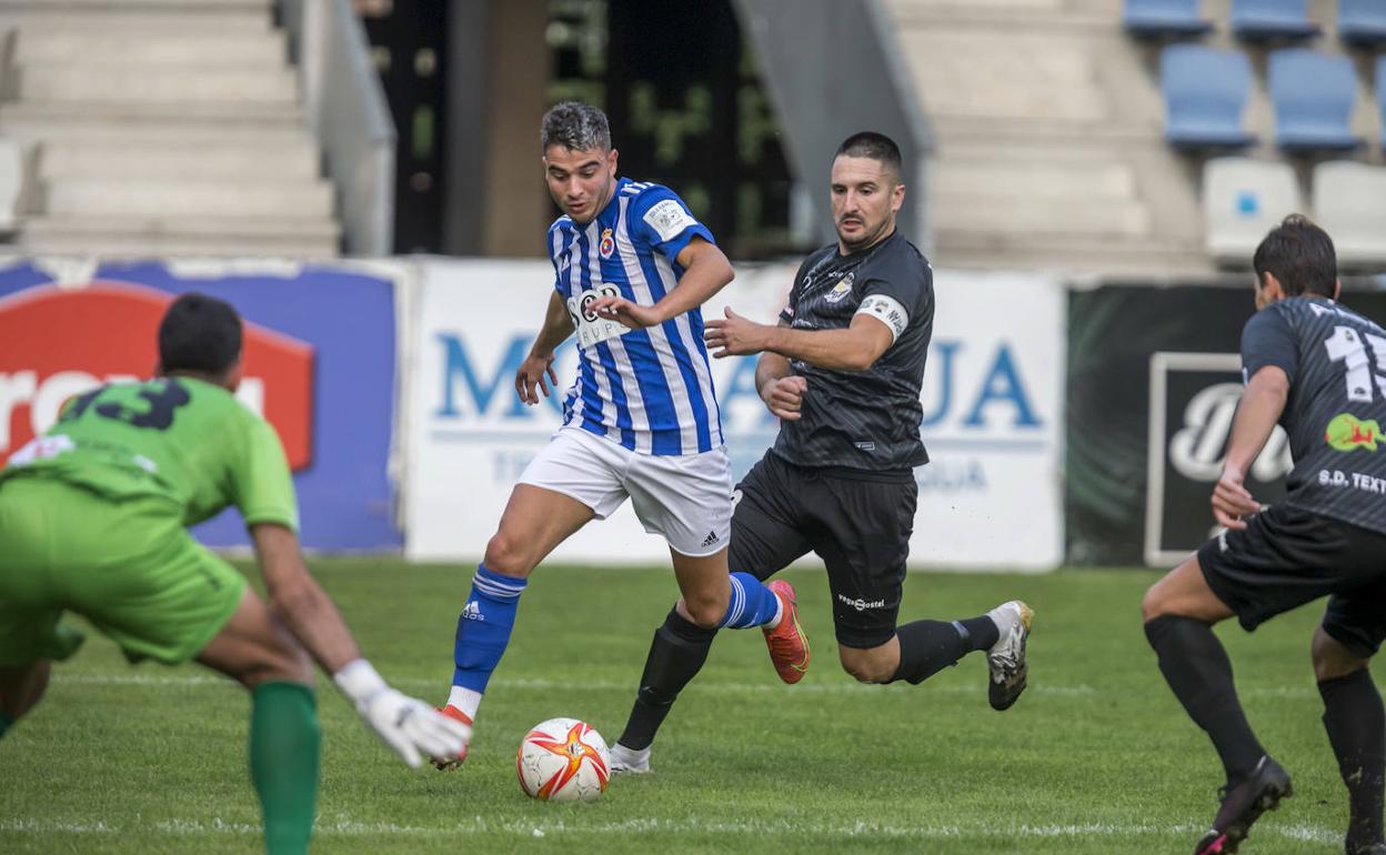 Héctor Tirado, de la Gimnástica, pelea por el balón con Aitor, del Textil Escudo