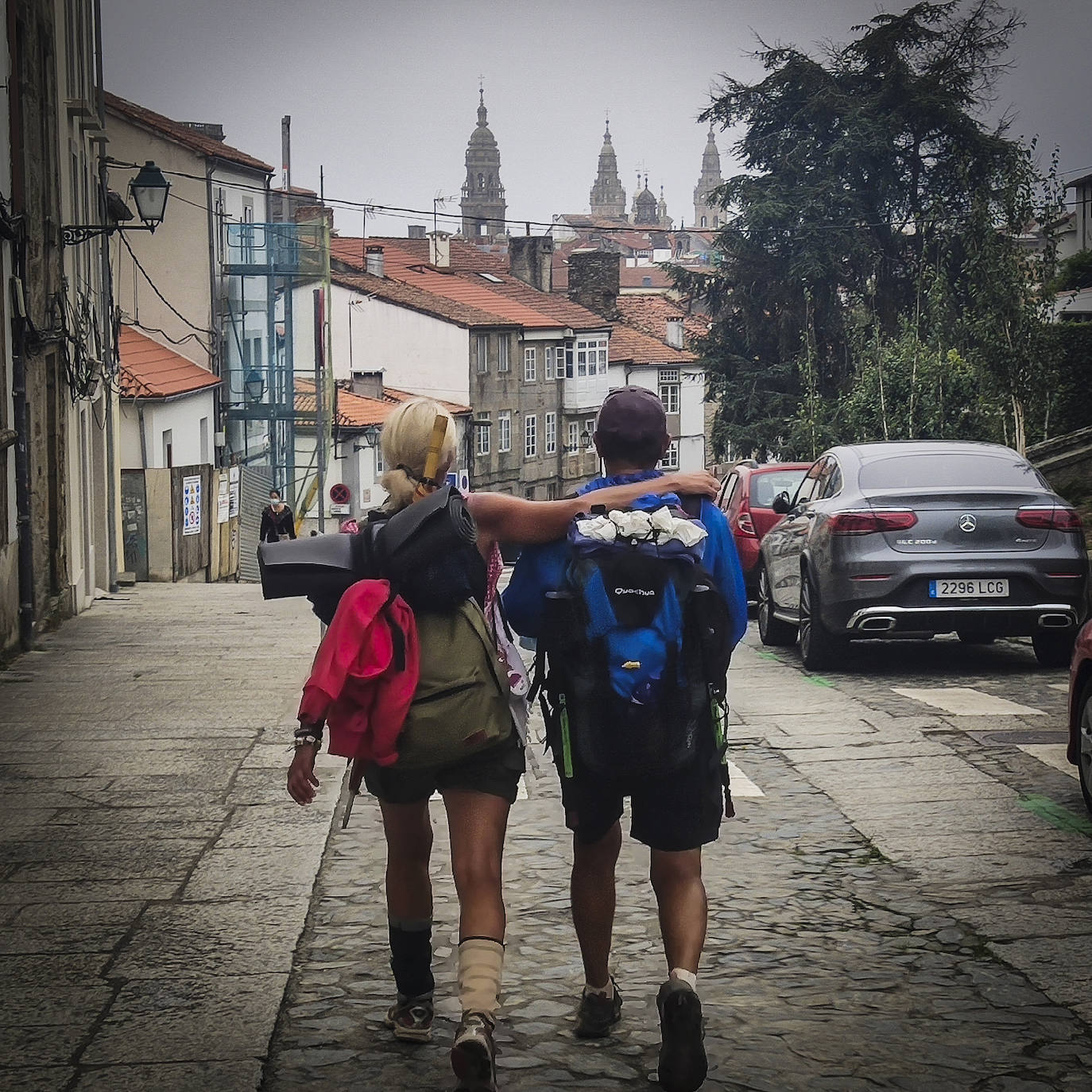 Por fin, la imagen con la que habíamos estado soñando desde que echamos a anfdar hace ya un mes. La de los tejados de Compostela, coronados por las torres de la catedral. Pilar y Luis llegan al Obradoiro fundidos en un abrazo.