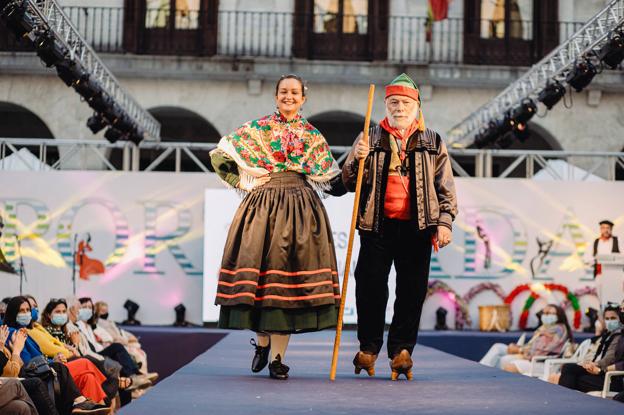 Pareja desfilando con trajes regionales.