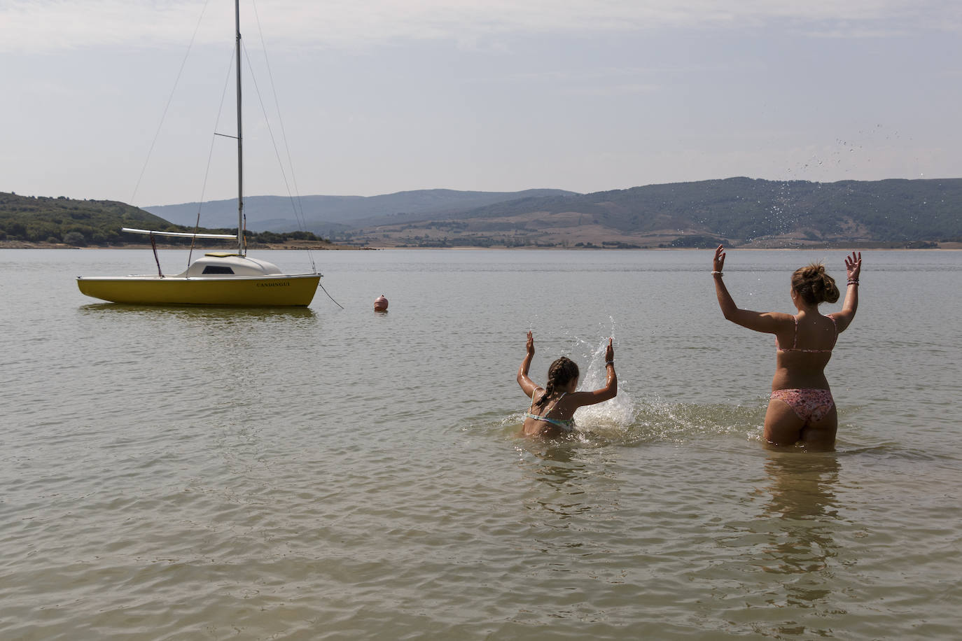 Los bañistas llegan al pantano del Ebro en busca de una jornada refrescante