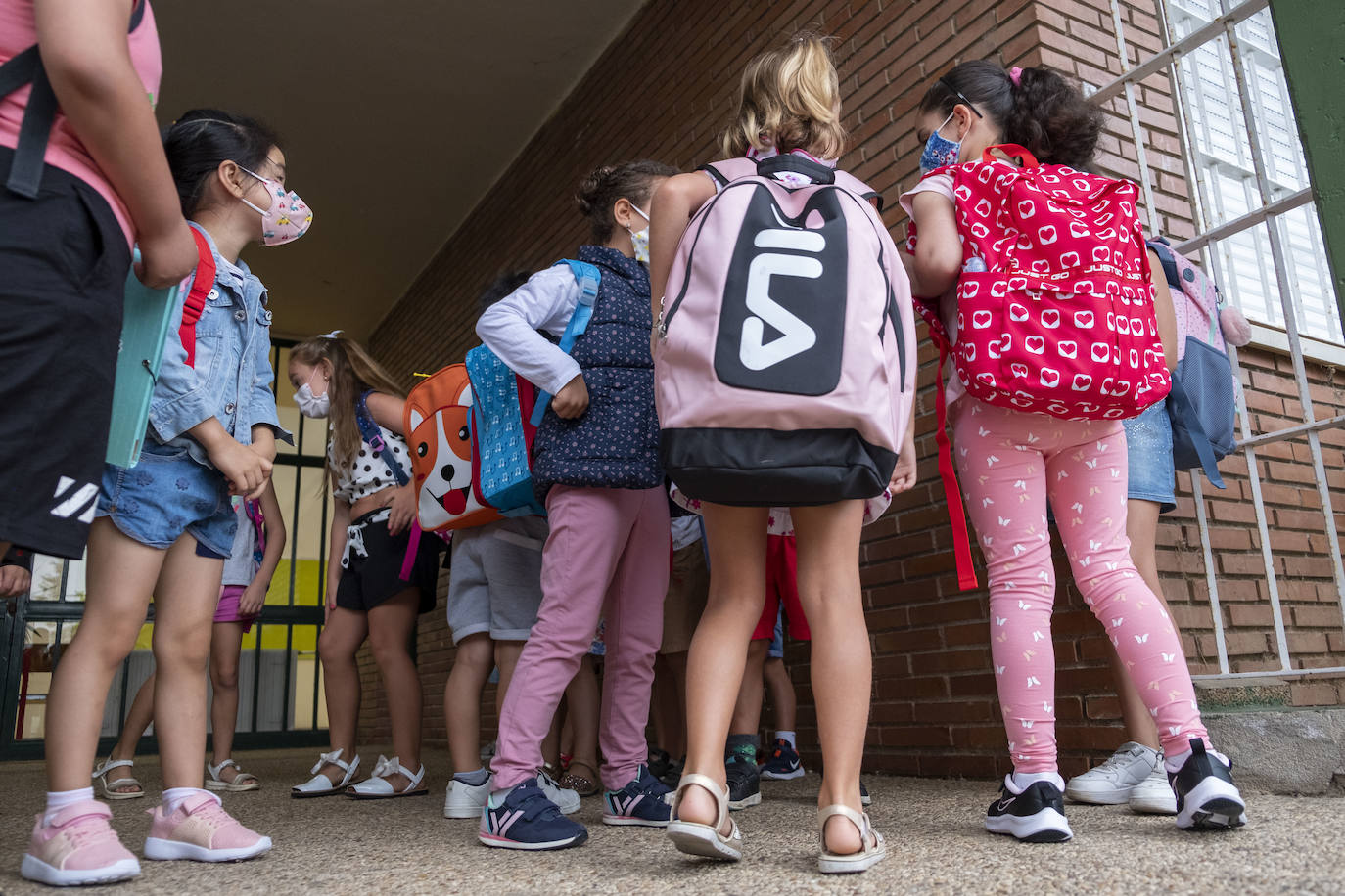 Los estudiantes del CEIP Gerardo Diego, en Santa María de Cayón, esperan a las puertas del colegio el arranque de la primera jornada del curso escolar