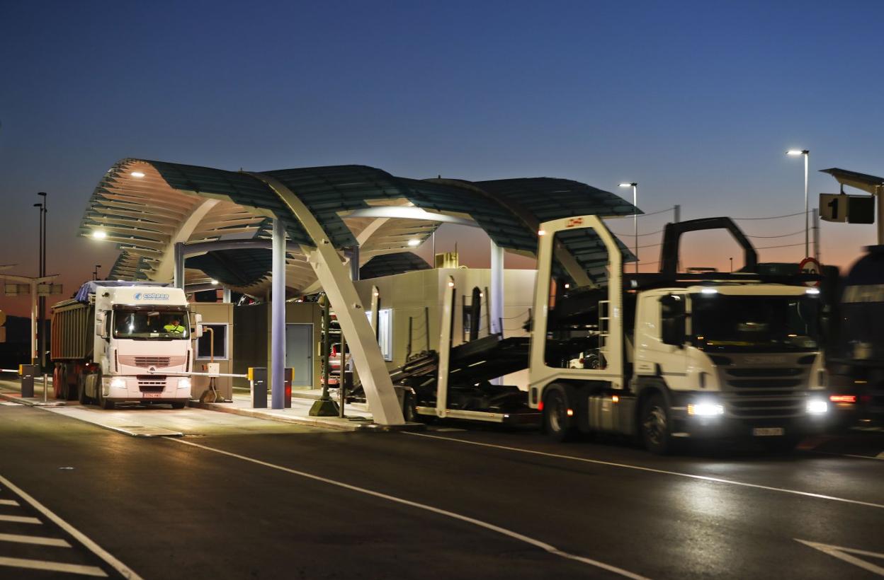 Dos camiones atraviesan el punto de acceso al recinto del Puerto de Santander. 