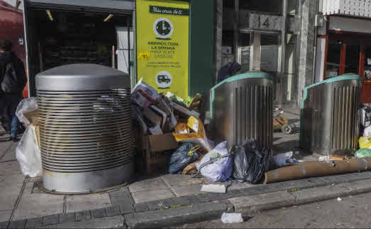 Bolsas esparcidas por el suelo, cajas de cartón y una alfombra junto a los buzones para basura orgánica en Nicolás Salmerón, barrio Castilla-Hermida, Santander