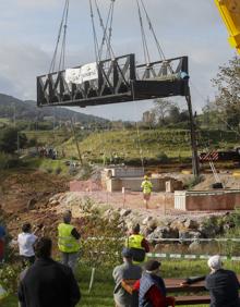 Imagen secundaria 2 - Recolocada la pasarela del puente de hierro de Solía tras reforzarse los cimientos