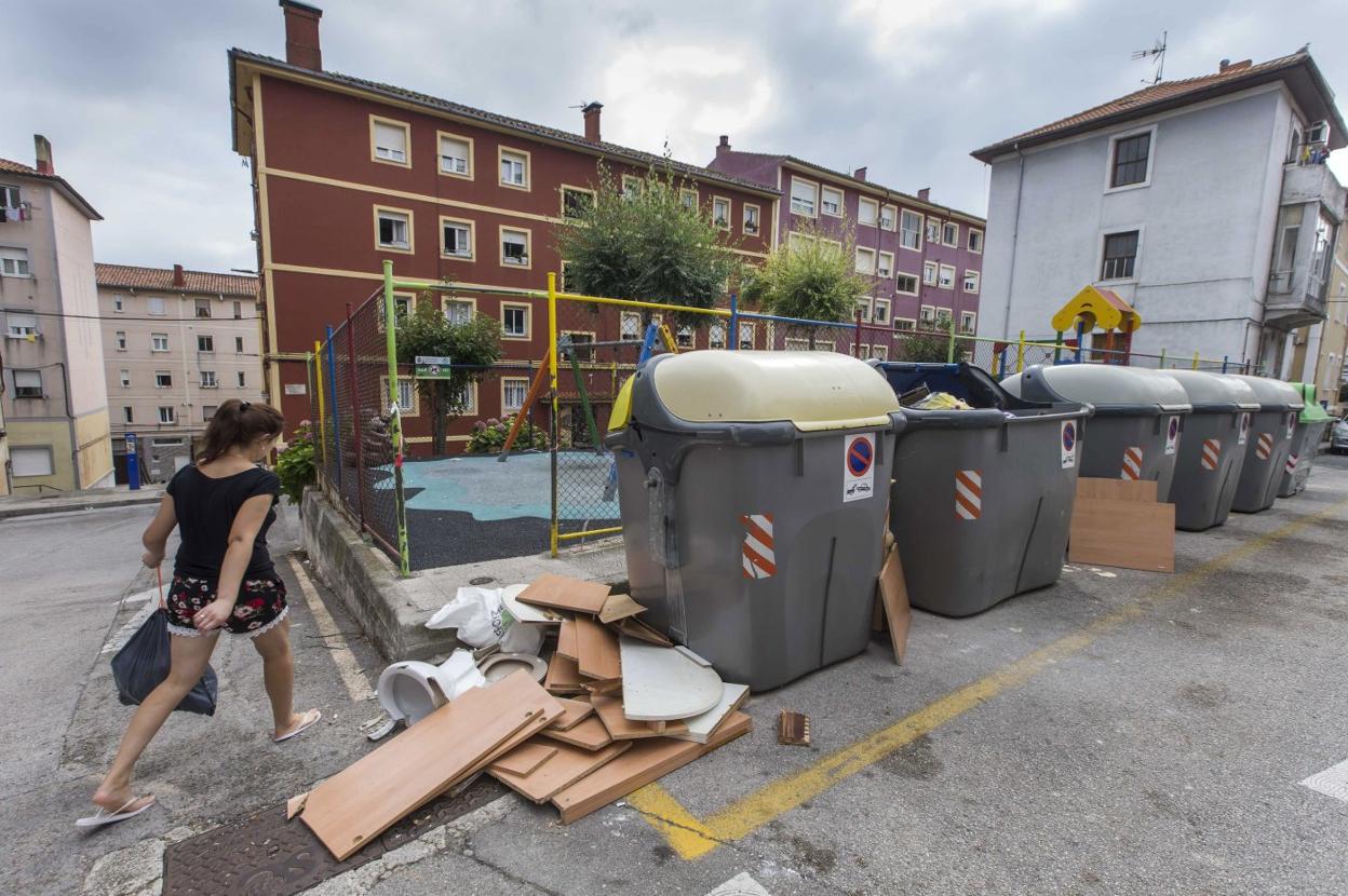 Contenedores rotos con basura acumulada alrededor, en el entorno de la calle Alta. 