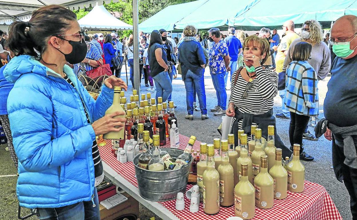 Una productora de orujo da a probar el licor a los visitantes. 