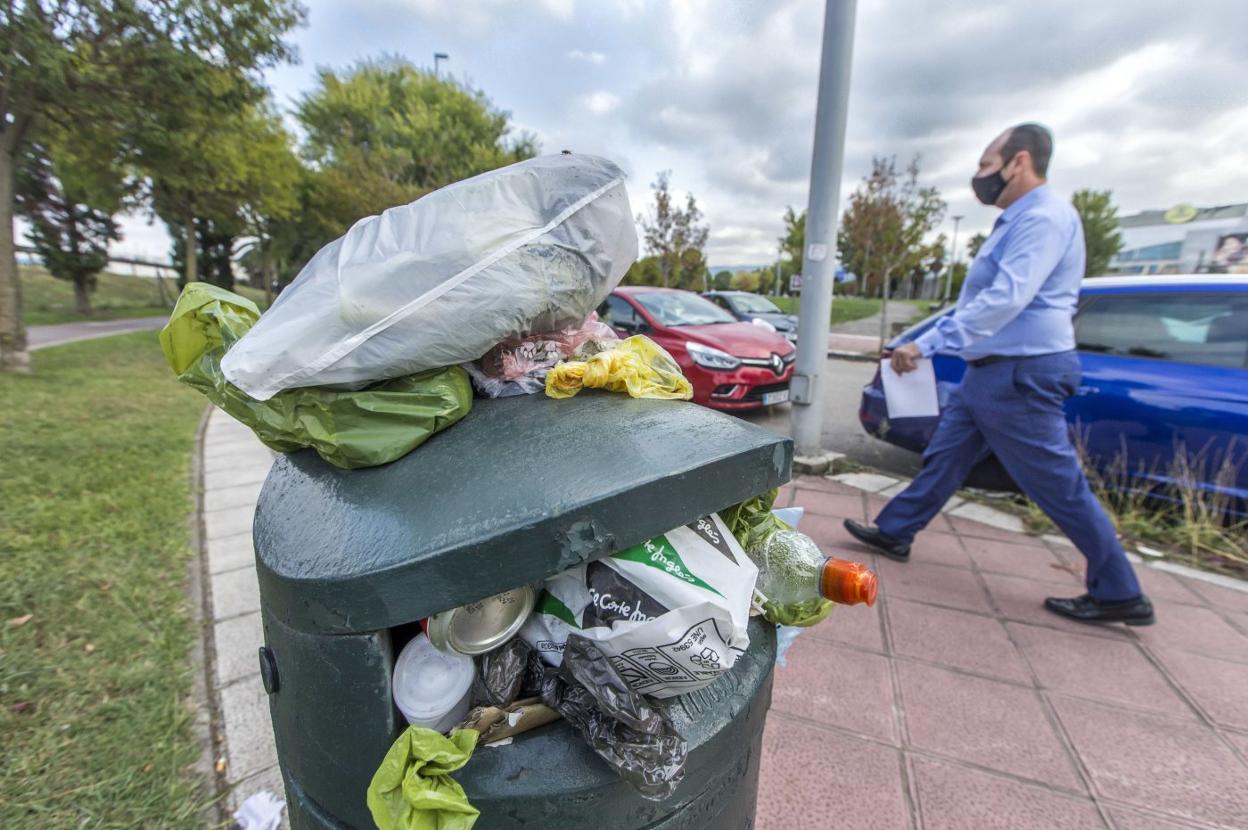 Una papelera hasta arriba de basura y con bolsas por encima, en el entorno de Nueva Montaña. 