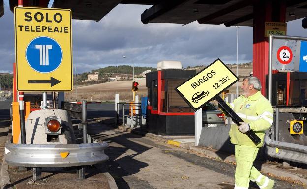 Un operario retira la señalización del peaje alavés de Armiñón de la autopista AP-1, en 2018 