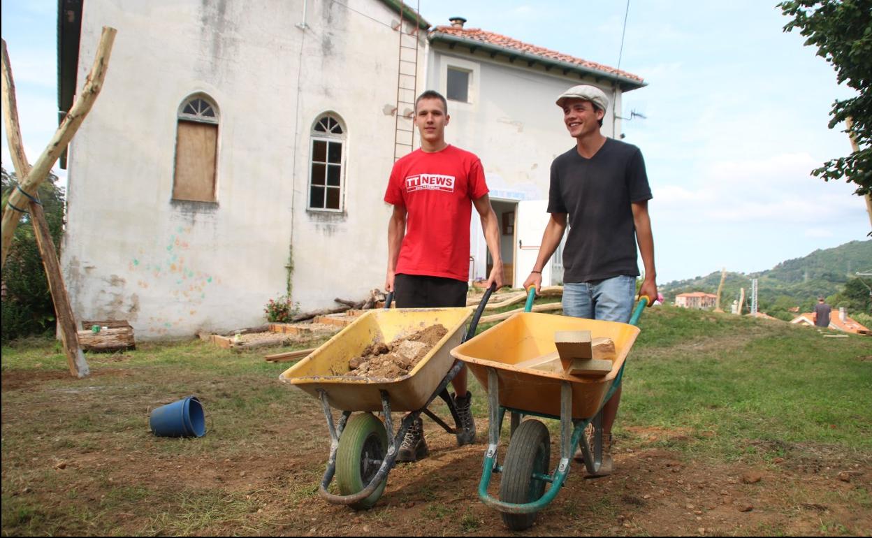Estudiantes alemanes ayudan en la construcción de un patio de juegos para la escuela Waldorf, tras ellos el edificio propiedad de la Iglesia. 