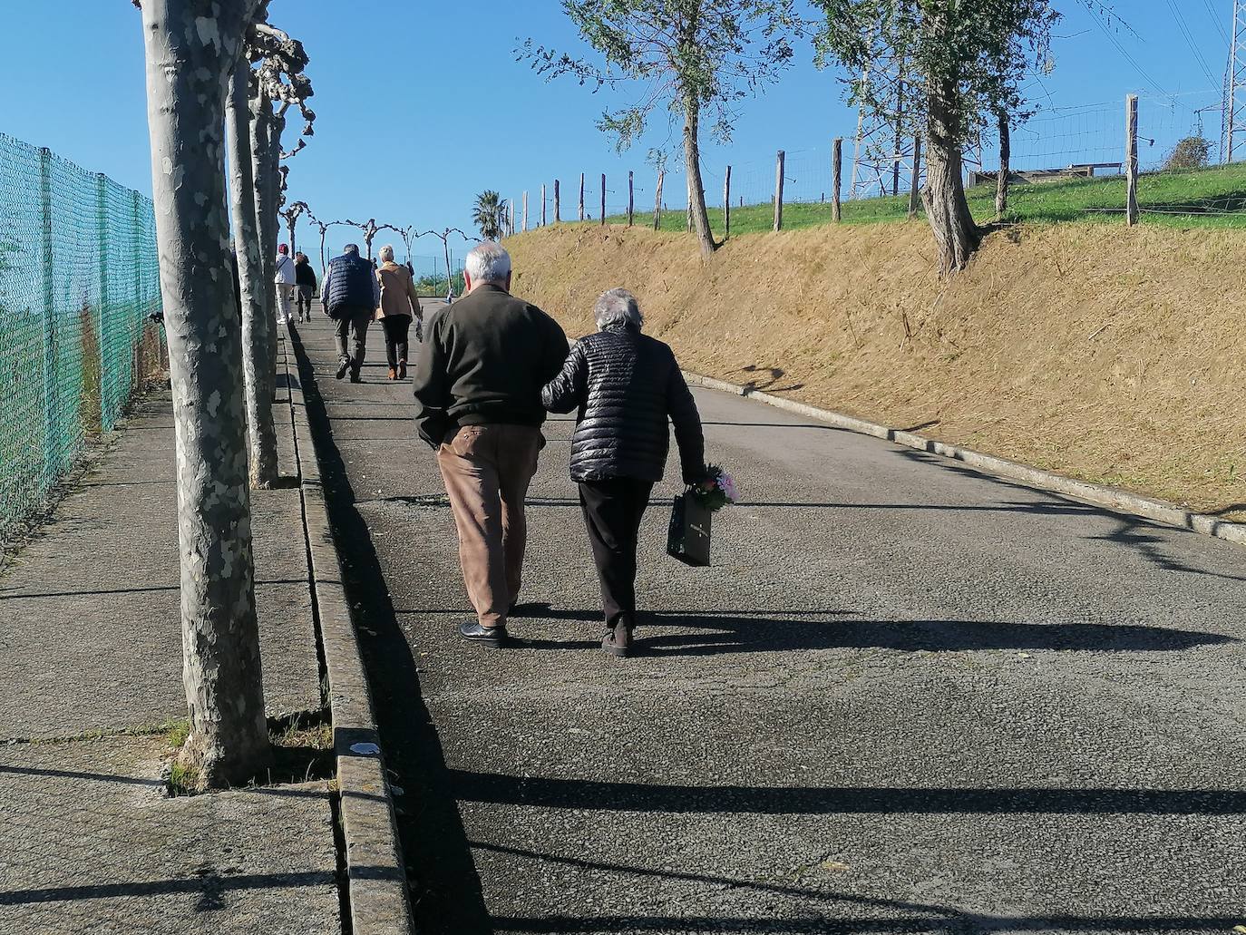 Gente llegando, a pie o en tren, al cementerio de Astillero, donde se celebró una misa al aire libre.
