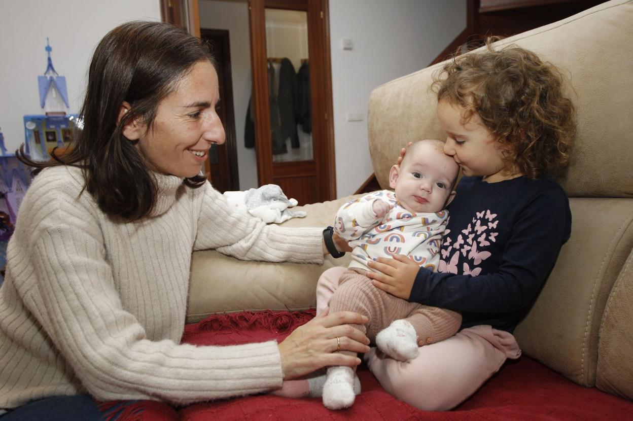 Laura Estrada, con sus hijas, Clara, que cuenta ya con seis meses, y Enezka, de tres años, en su casa. 