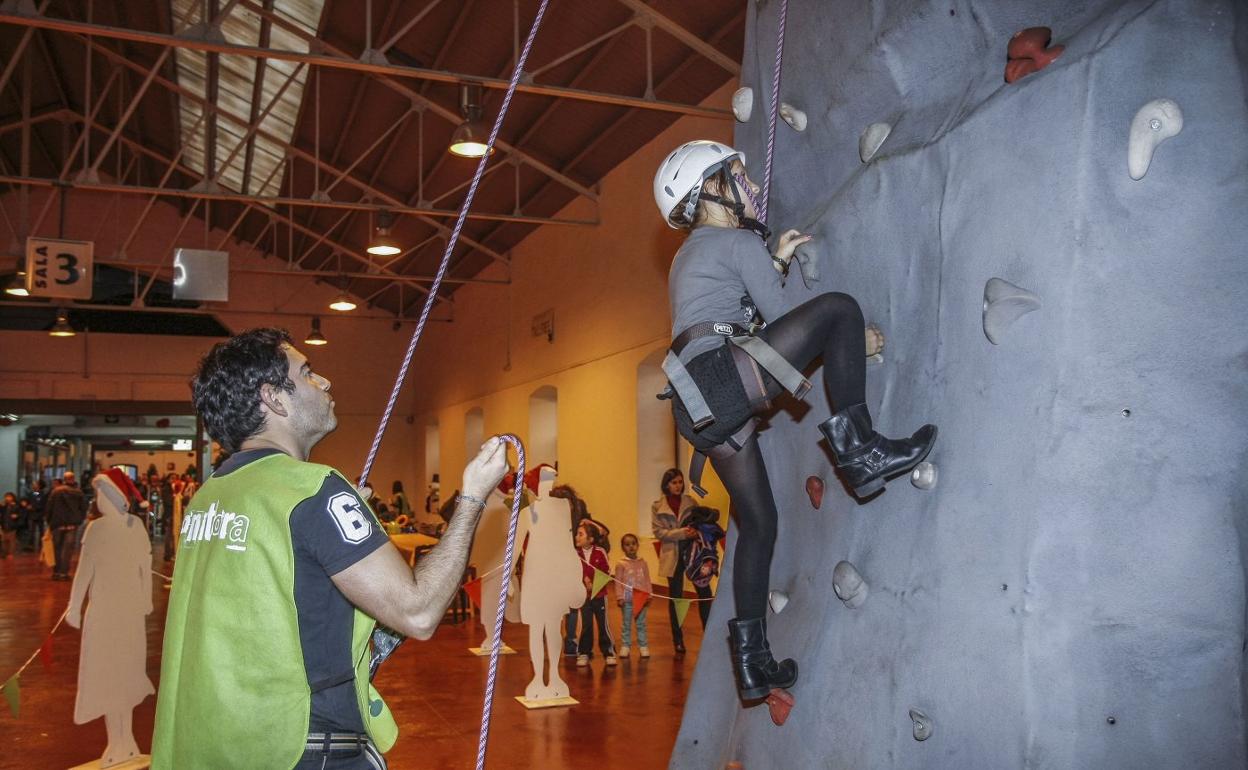 Una niña escala en un rocódromo instalado en La Lechera en una edición anterior de la Feria de Navidad. 