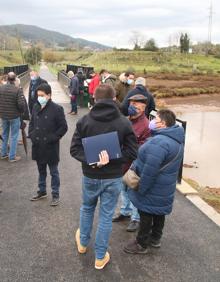 Imagen secundaria 2 - Arriba, la nueva pasarela sobre la ría. Abajo, Javier Fernández Soberón, José Luis Gochicoa, Elías Celis (gerente de Rucecan) y Constantino Fernández. Y otros peatones e invitados a la inaguración del puente.