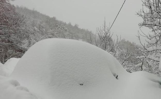 Imagen principal - Arriba, un coche totalmente sepultado por la nieve en las inmediaciones de Piedrasluengas. Un vecino retira la nieve en Cucayo (Vega de Liébana) y Venta Pepín, en el acceso al puerto de Piedrasluengas.