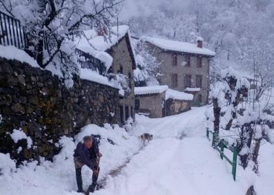 Imagen secundaria 1 - Arriba, un coche totalmente sepultado por la nieve en las inmediaciones de Piedrasluengas. Un vecino retira la nieve en Cucayo (Vega de Liébana) y Venta Pepín, en el acceso al puerto de Piedrasluengas.