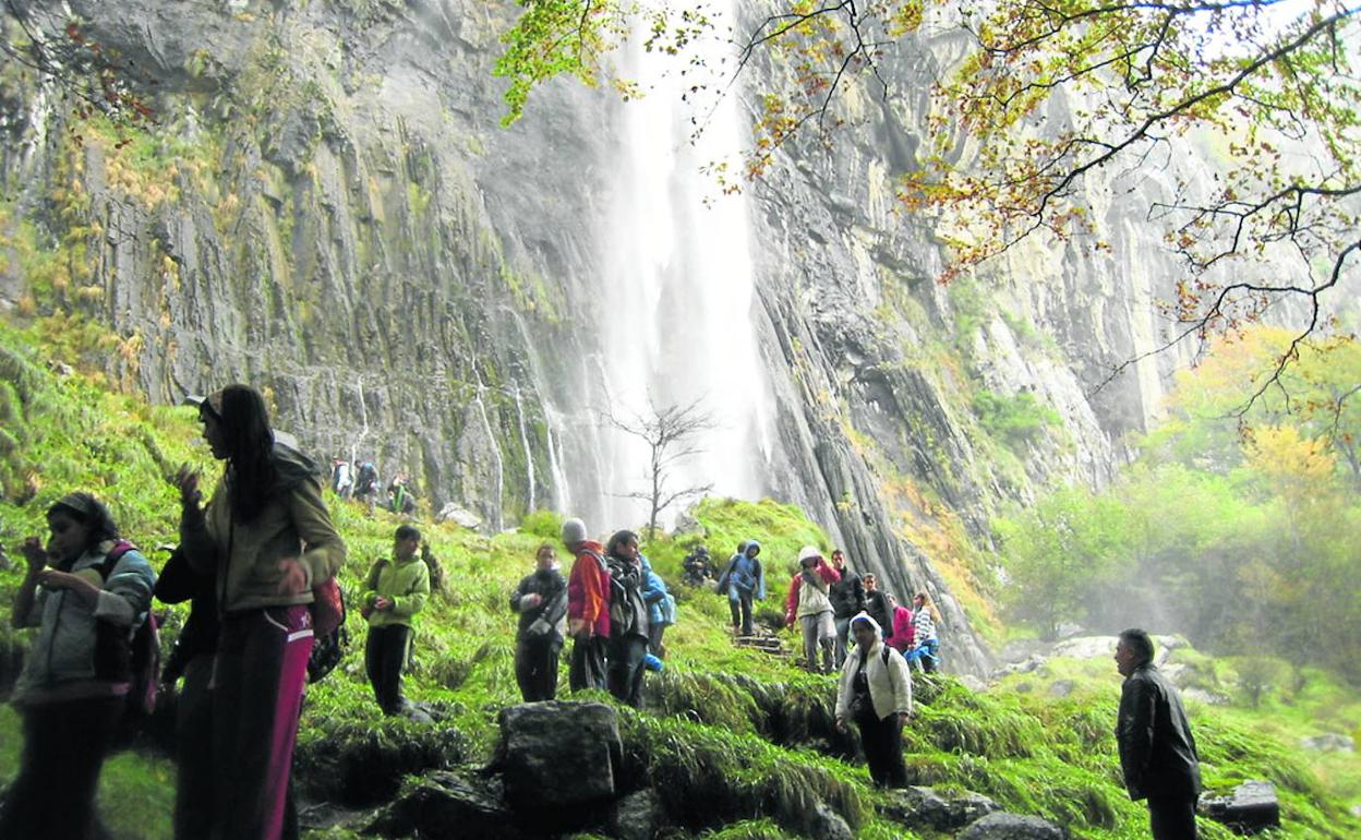 Un grupo de visitantes, ante la imponente cascada del Asón, uno de los grandes atractivos de la zona.