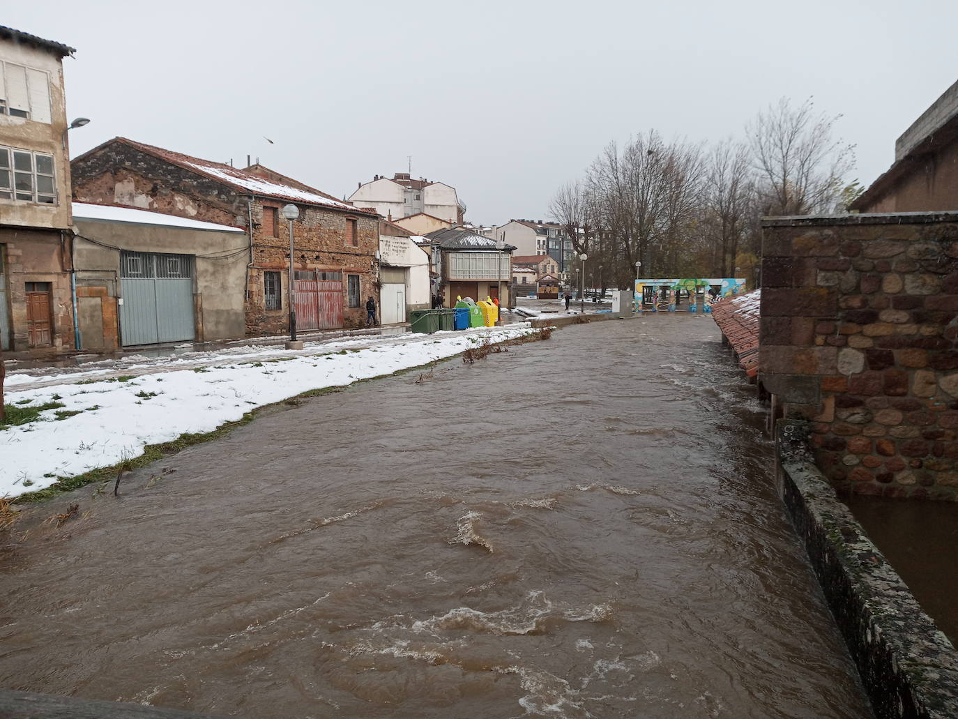 El río Ebro desbordado por las calles de Reinosa, esta mañana.