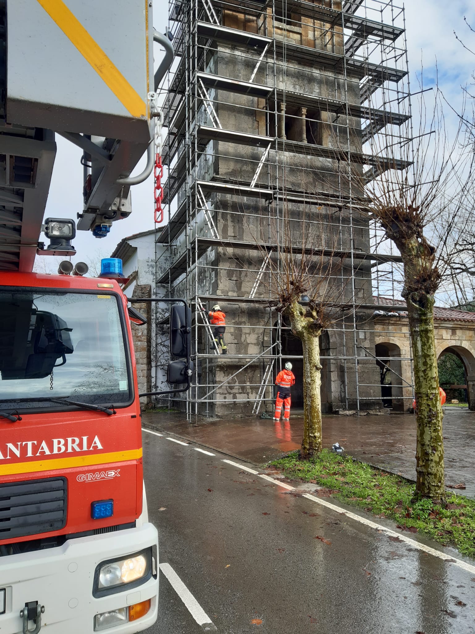 Los bomberos del 112 colocan las champas de un andamio movidas por el viento con riesgo de caída en Udalla (Ampuero). 