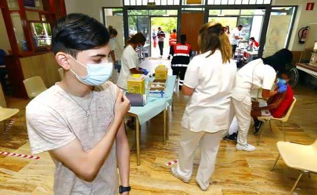 Un adolescente aprieta una gasa contra su brazo tras recibir la vacuna anticovid. 