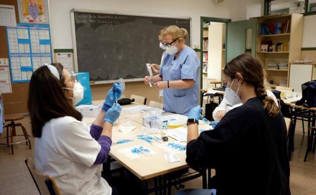 Un grupo de sanitarias preparando dosis de vacunas. 