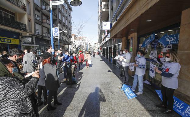 Los trabajadores de la administración agraciada de Santoña celebran el Gordo, con público y la prensa.