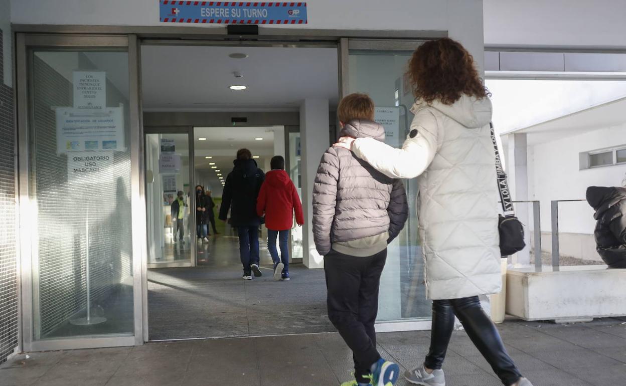 Un menor acude acompañados a vacunarse en el centro de salud de El Alisal.