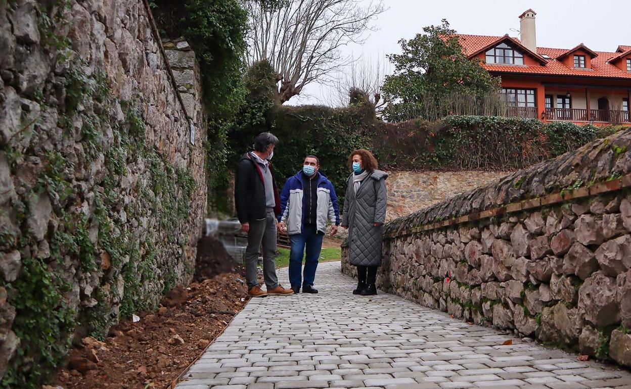 Los concejales Pedro Velarde y Julián Rozas atraviesan el vial recién asfaltado con la alcaldesa, Teresa Noceda. 