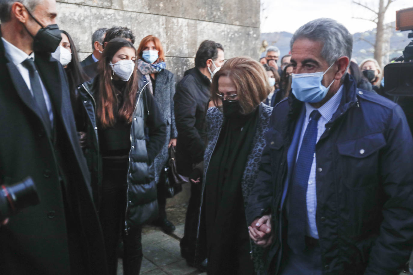 La mujer de Paco Gento y el presidente de Cantabria agarrados de la mano a las puertas de la iglesia donde ha tenido lugar el funeral.