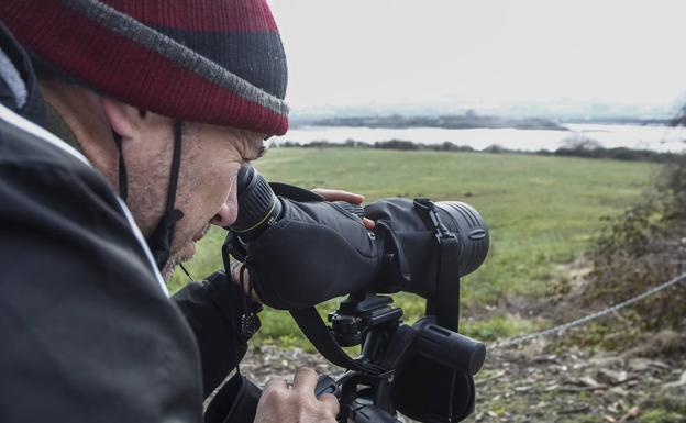 Con un telescopio terrestre el experto cuenta una a una el número de aves que observa