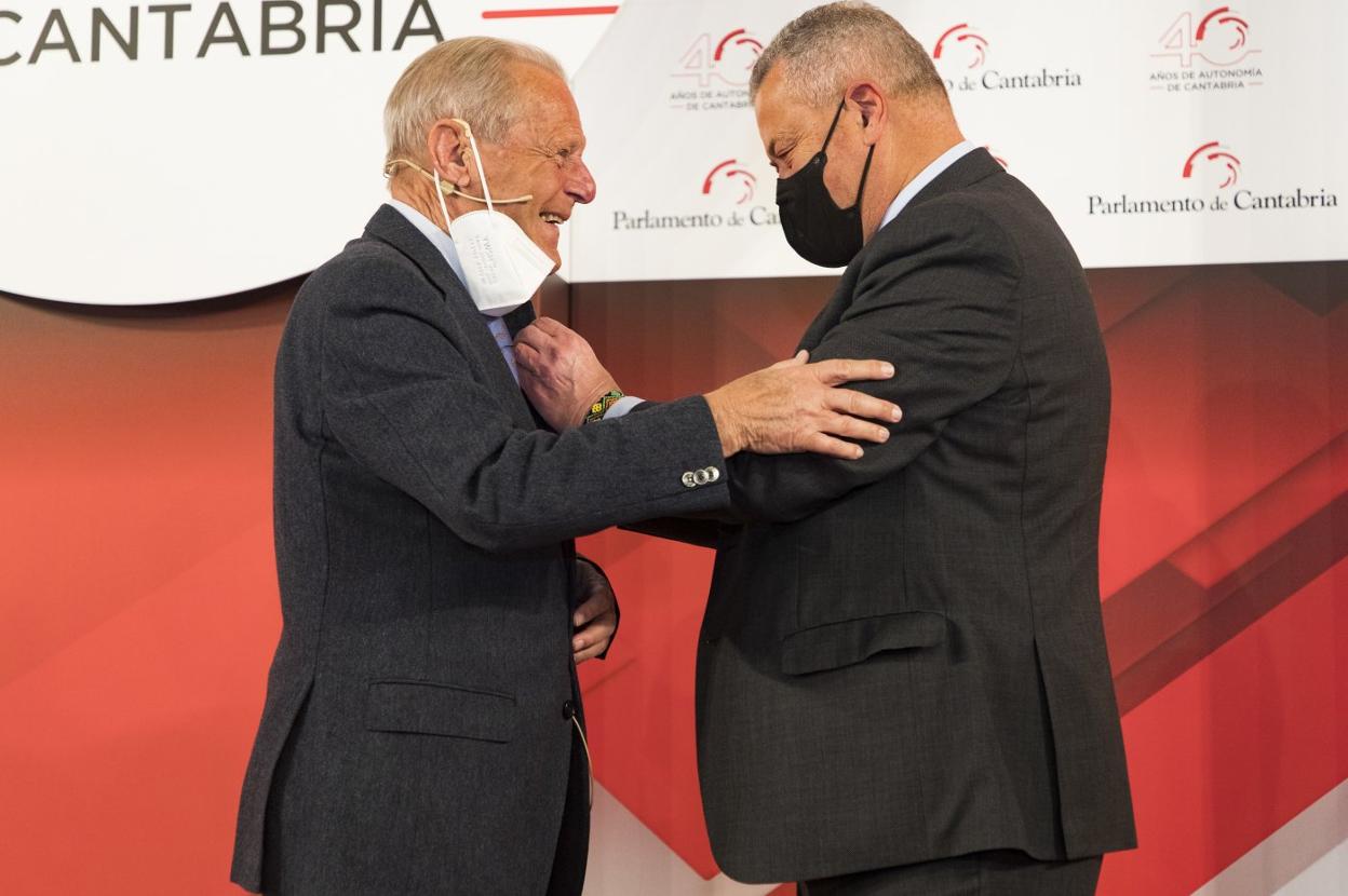 El presidente del Parlamento, Joaquín Gómez, coloca la insignia de la institución a José Antonio Rodríguez, primer presidente regional. 