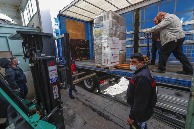 Un grupo de ucranianos carga en el camión el primer palé con material de primera necesidad. 