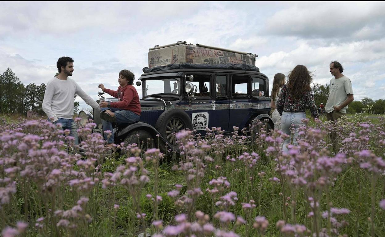 La familia, durante un alto en el camino rodeada de naturaleza.