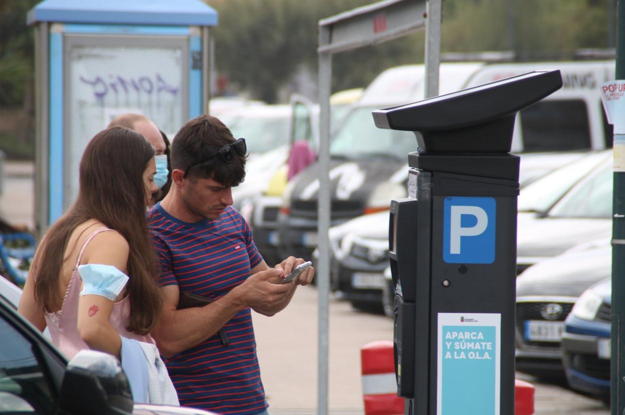 Dos visitantes expiden su tique de aparcamiento junto al Centro de Surf de Somo. 